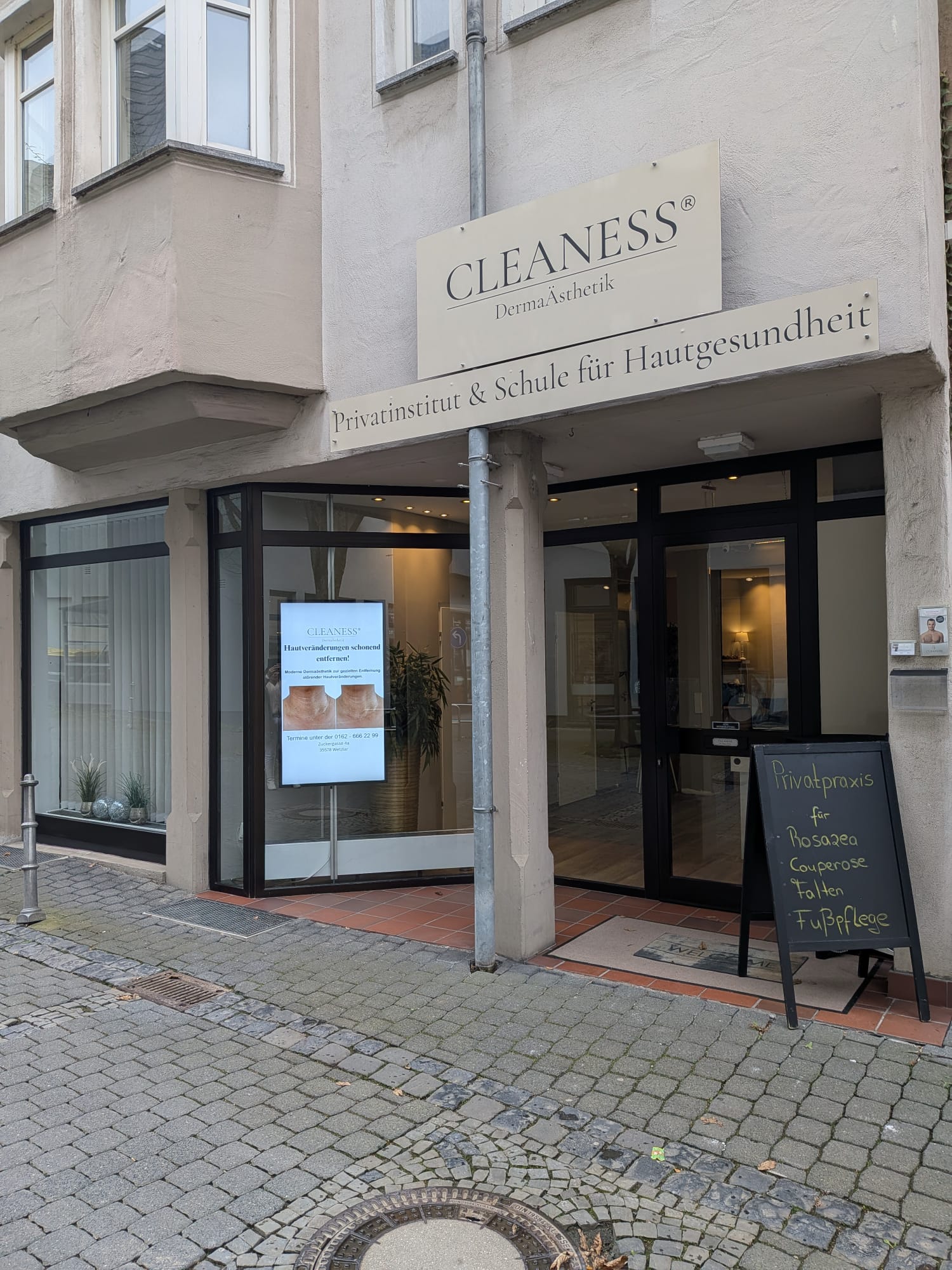 CLEANESS® Praxis Außenansicht am Abend – beleuchteter Eingang in Wetzlar